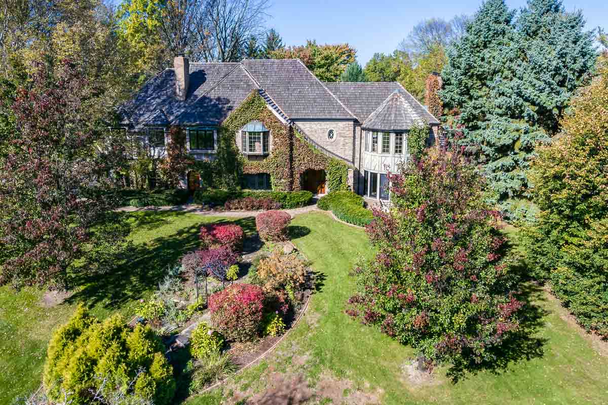 Aerial-Photography Beautifully landscaped home with ivy on front exterior and the trees in autumn colors