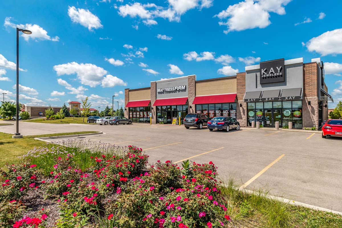 Commercial-Real-Estate-Photography Store front of a Mattress Firm and Kay Jewelers with flower bed in the foreground.