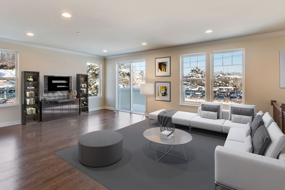 Room that was virtually staged with white couch and chase, gray carpet, coffee table, ottoman, and bookshelves next to tv and hutch.